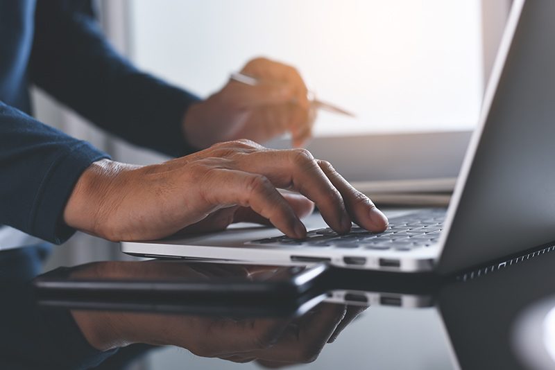 hands typing on a keyboard.