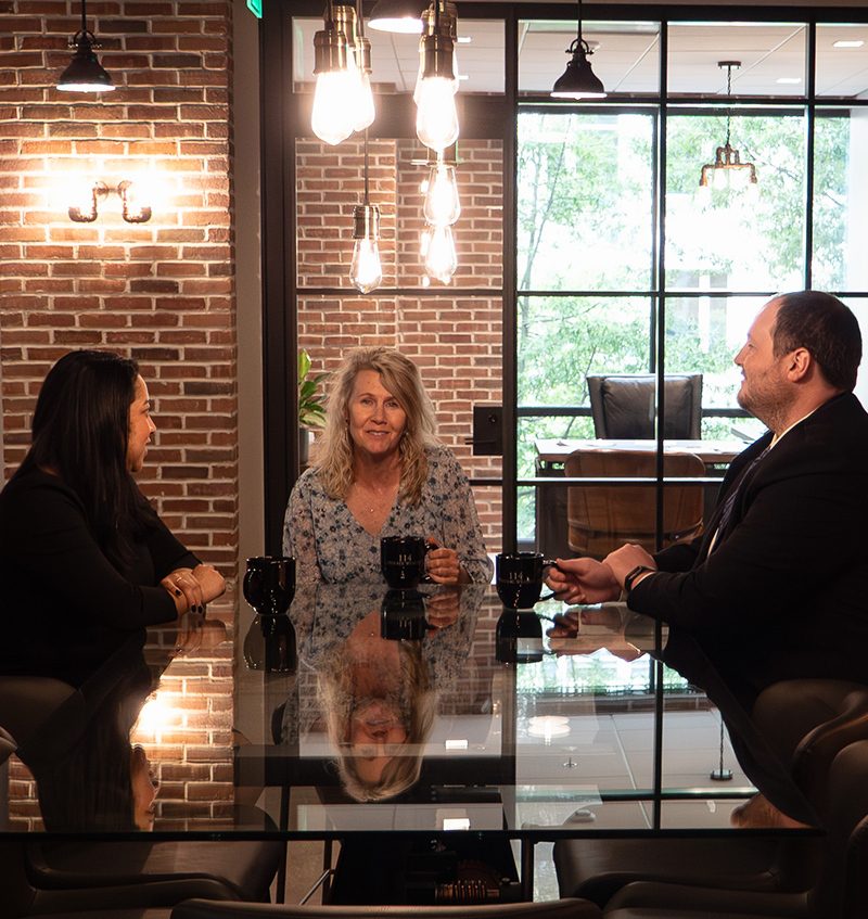 Group of 114 advisors talking around a glass table.